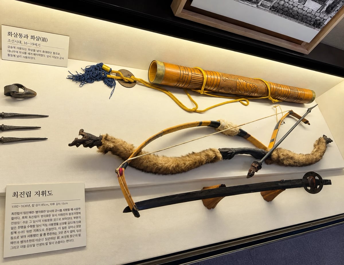General Choe Jin-rip's command sword (崔震立指揮刀) and a bow — the sword (blade 85 cm, hilt 15 cm) was used to command troops in the Imjin and Byeongja wars.